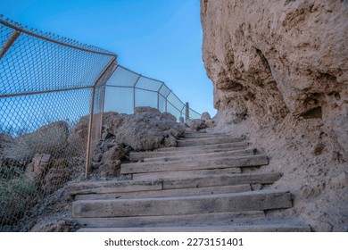Phoenix, Arizona- Hiking trail at Camelback Mountain with rocks and chainlink fence on the steps. Trail with manmade steps and chainlink fence on the left and rock wall on the right.