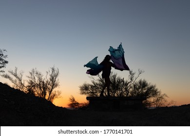 Phoenix, Arizona / USA - July 4, 2020: A Woman Dances With Flags In The Phoenix Mountains Preserve At Sunset. 