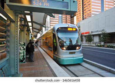 PHOENIX, AZ / USA - JANUARY 8 2011:  A Valley Metro Light Rail Trolley Eastbound For Mesa, Stops At Jefferson/1st Ave Station. Across The Street Is Five Guys And Jimmy John's.