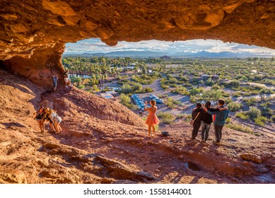 Phoenix, USA - October 13, 2018: People snap pictures of themselves in the mouth of Hole-in-the-Rock, a tourist attraction in Papago Park, Arizona.