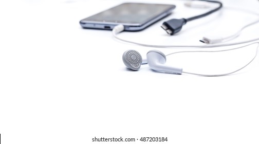 Phone accessories, usb cables, headphones on a white wood background