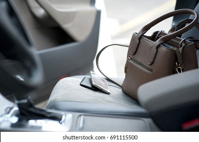 Phone And Bag Lie On The Car Seat