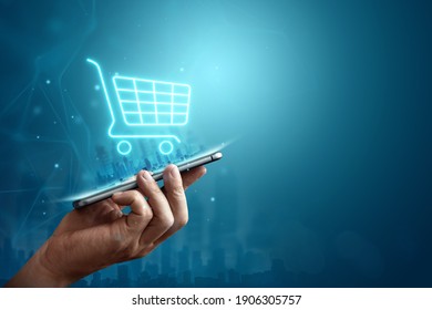 Phone and basket hologram. Online shopping, online store application in a smartphone. Digital Marketing Online - Shutterstock ID 1906305757