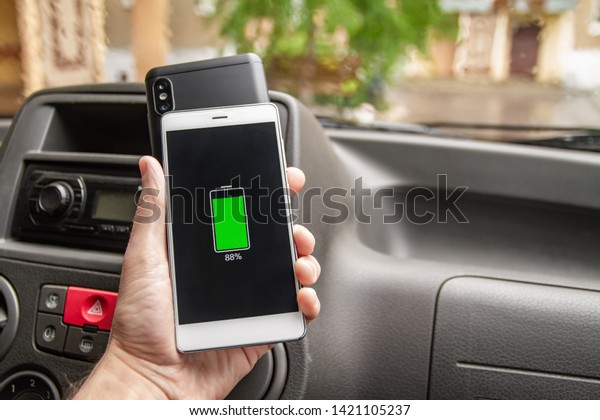 Phone battery
wireless charge sharing technology. Wireless charge sharing
smartphone in the car in rainy
weather