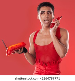 Phone call, beauty and gay man talking with a sassy attitude and red outfit in a studio. Conversation, mobile and beautiful lgbtq male with a cosmetics, makeup and style isolated by a red background.