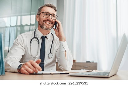 Phone call, laptop and male doctor doing a telehealth consultation in his office in the hospital. Technology, communication and senior man healthcare worker on a mobile conversation in medical clinic - Powered by Shutterstock