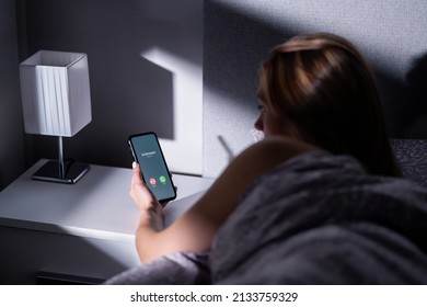 Phone Call Scam From Unknown Caller. Smartphone Fraud From Mobile Number At Night. Woman In Bed Answering To Incoming Hoax, Prank Or Phishing Crime. Stalker, Stranger Or Fake Person. Holding Cellphone