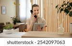 Phone call, spa and woman at reception with tablet checking website for online booking schedule. Consultant, receptionist or girl at front desk on telephone, digital app or appointment at hotel salon