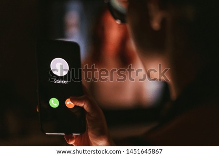 Phone call from a stalker late at night. Stalking or bullying with smartphone concept. Stalker caller, scammer or stranger. Woman answering to incoming call. Ex boyfriend with fake identity.