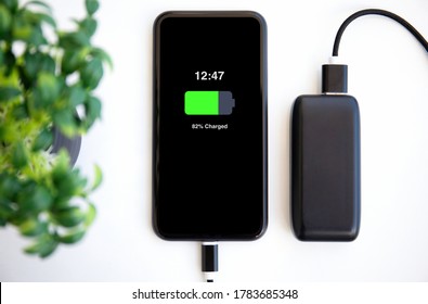 Phone With Charged Battery On The Screen Connected To Powerbank Charge