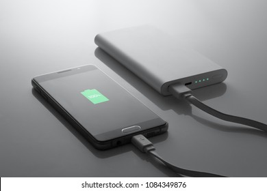 The Phone Is Charged From The Powerbank, In Dark Tones, 100% Charge