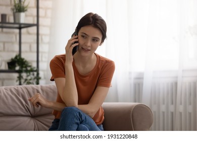 Phone Conversation. Confident Young Woman Sit On Couch Talk Speak Communicate By Telephone From Home Holding Device At Ear. Teen Female Make Answer Call Using Cell Listen To Friend Parent. Copy Space