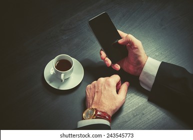 Phone And A Cup Of Coffee In The Hands Of A Businessman. Stylish Business Still Life In Dark Colors