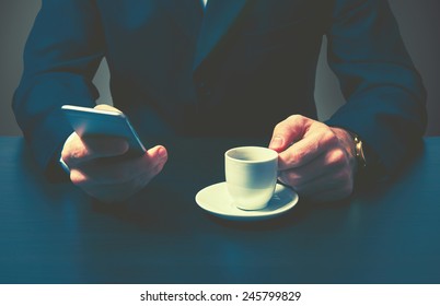 Phone And A Cup Of Coffee In The Hands Of A Businessman. Stylish Business Still Life In Dark Colors