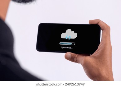 Phone data backup and cloud data storage concept. Man using a smartphone to upload data to cloud storage.