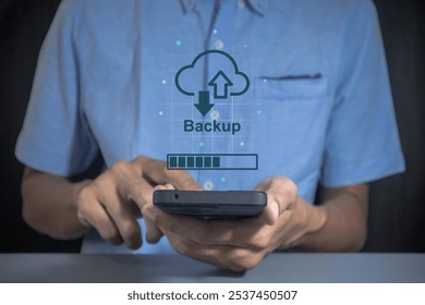Phone data backup and cloud data storage concept. Man using a smartphone to upload data to cloud storage.