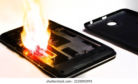  Phone explosion on a white background. The phone is on the table and is on fire. telephone short circuit.