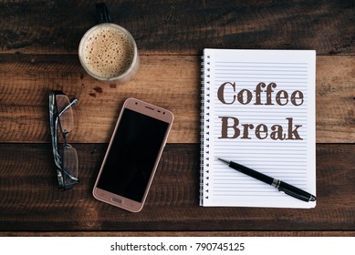 Phone, Glasses, Coffee Mug And Notebook With COFFEE BREAK Word On Wooden Table. Coffee Break Conceptual