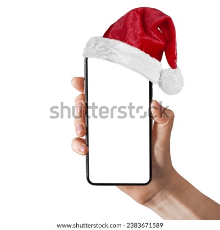 a phone in a hand with a Santa Claus hat for Christmas