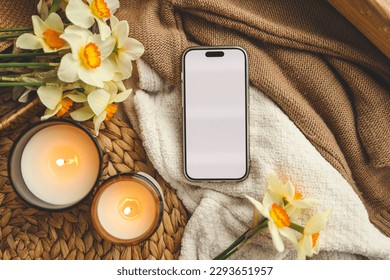 Phone with isolated screen and spring composition of candles and flowers.