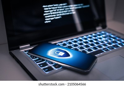 Phone lock to protect from cyber scam, online data fraud or identity theft. Laptop with hacker virus code in screen. Phishing, cybersecurity danger or ransomware attack. Encrypted privacy in email. - Shutterstock ID 2105064566