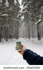 The Phone And Map In The Hands Of Men Hiking Winter Forest