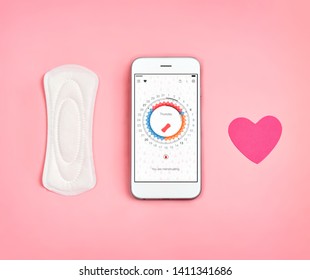 Phone with menstrual calendar. Sanitary napkin and heart symbol on pink background. Concept of critical days, menstruation - Powered by Shutterstock