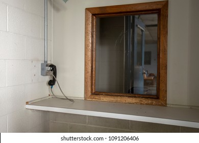 Phone next to window used by visitors to prison to communicate with inmates behind glass.