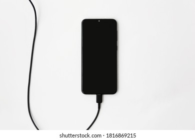 
Phone On Charge On A White Background