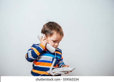 Phone On The Wire. Child Speaks On The Phone Wire. Boy Talking On A Wired Phone