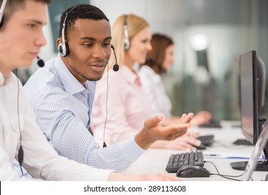 Phone Operator Working At Call Centre Office Helping Hiss Colleague.