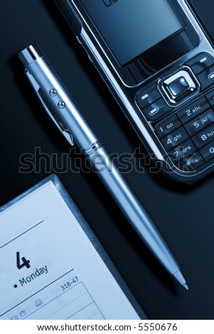 Phone, pen and notebook on a table