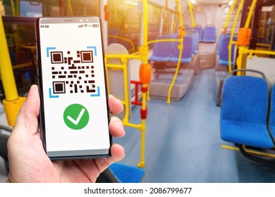 Phone with QR code. Using QR technologies. Public transport payment concept using QR code. Tag for payment for travel. Hand with smartphone inside public bus. Selective focusing. Municipal bus