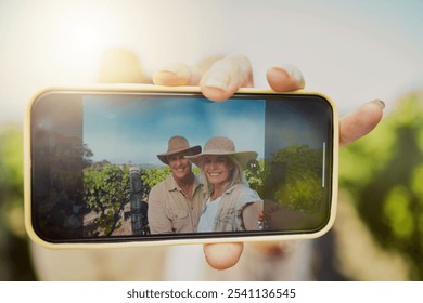 Phone screen, hand and selfie of happy couple at vineyard for vacation, holiday or travel closeup. Senior man, woman and picture at winery farm with mobile for memory or photo on date by grape field - Powered by Shutterstock