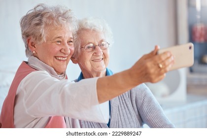 Phone, selfie and elderly friends smile for pictures to share on social media online while relaxing in retirement. Happy, love and senior women smiling while enjoy quality time at home in Berlin - Powered by Shutterstock