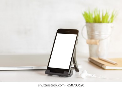 Handy mit weißem Blankobildschirm auf dem Schreibtisch