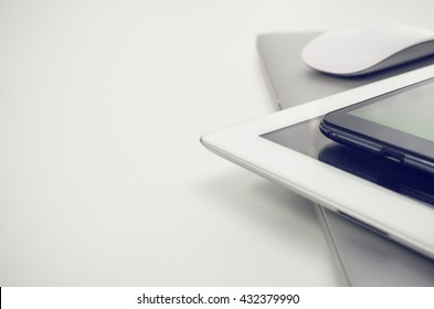 Phone, Tablet Pc, Notebook And Mouse On White Desk.