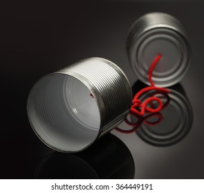 phone toy from a tin can lying on a smooth black polished table