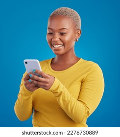Phone, typing and black woman in studio with smile for social media, text message and browse website. Communication mockup, technology and girl on internet, network and chat online on blue background - Shutterstock ID 2276730889