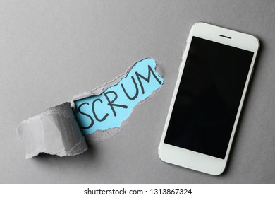 Phone And Word SCRUM Visible Through Torn Paper