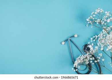 Phonendoscope on a blue background. Medical attributes and copy space. Background for doctor's day or international nurse's day. Flowers for a doctor - Shutterstock ID 1966865671