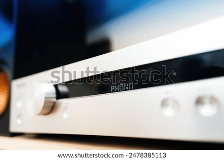 Phono turntable input on a preamplifier in an audiophile room, low-angle view of the aluminum panel on the front, showcasing premium design and high-quality audio equipment