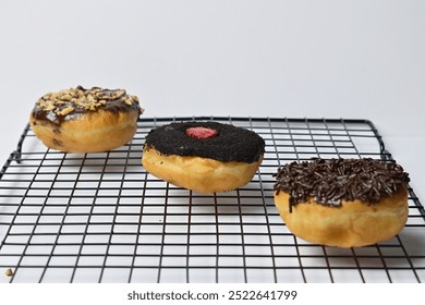 Photo of 3 or three donuts on the black baking rack. Isolated on the white background. - Powered by Shutterstock