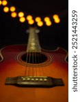 Photo of acoustic guitar with black background and lights