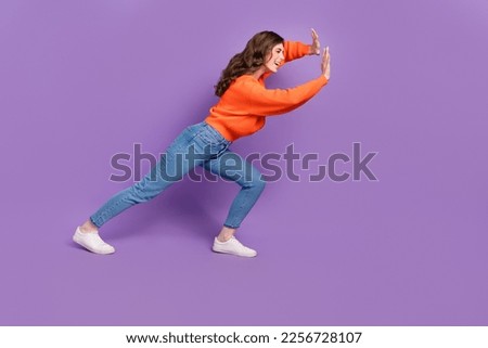 Photo of active motivated lady push large empty space board billboard isolated on purple color background