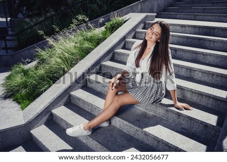 Photo of adorable cute lovely positive girl sitting on stairs walking in park after university lectures warm autumn weather outdoors
