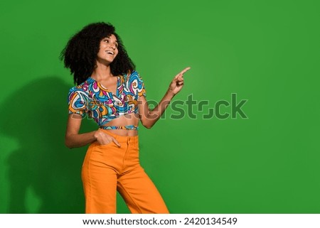 Photo of adorable lady wearing trendy old style fashion pointing finger empty space looking for more isolated on green color background
