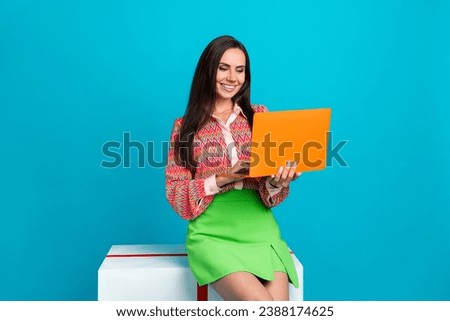 Photo of adorable lovely lady sitting cube working remote wireless netbook isolated on cyan color background