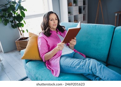 Photo of adorable lovely senior woman sitting sofa reading book weekend time comfy indoors - Powered by Shutterstock