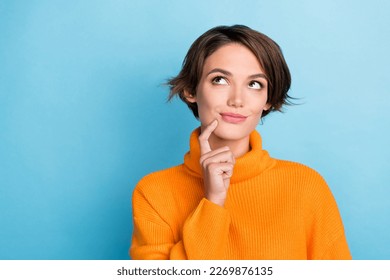 Photo of adorable nice lady finger touch chin look interested empty space isolated on blue color background